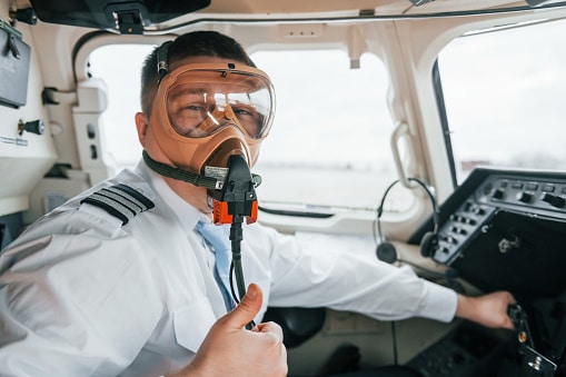 In oxygen mask. Pilot on the work in the passenger airplane. Preparing for takeoff